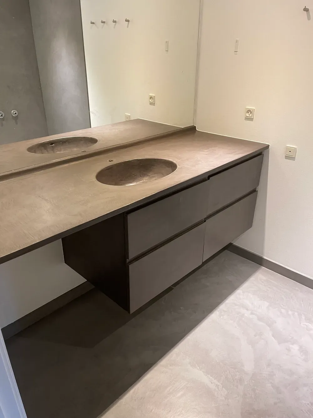 Moderne badeværelsesdesign med grå microcement på gulvet