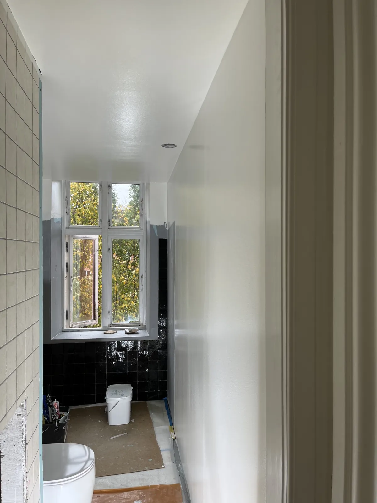 Færdigt badeværelse med hvid væg, sort møbel og vindue – Maler Microcement, Herlev og omegn