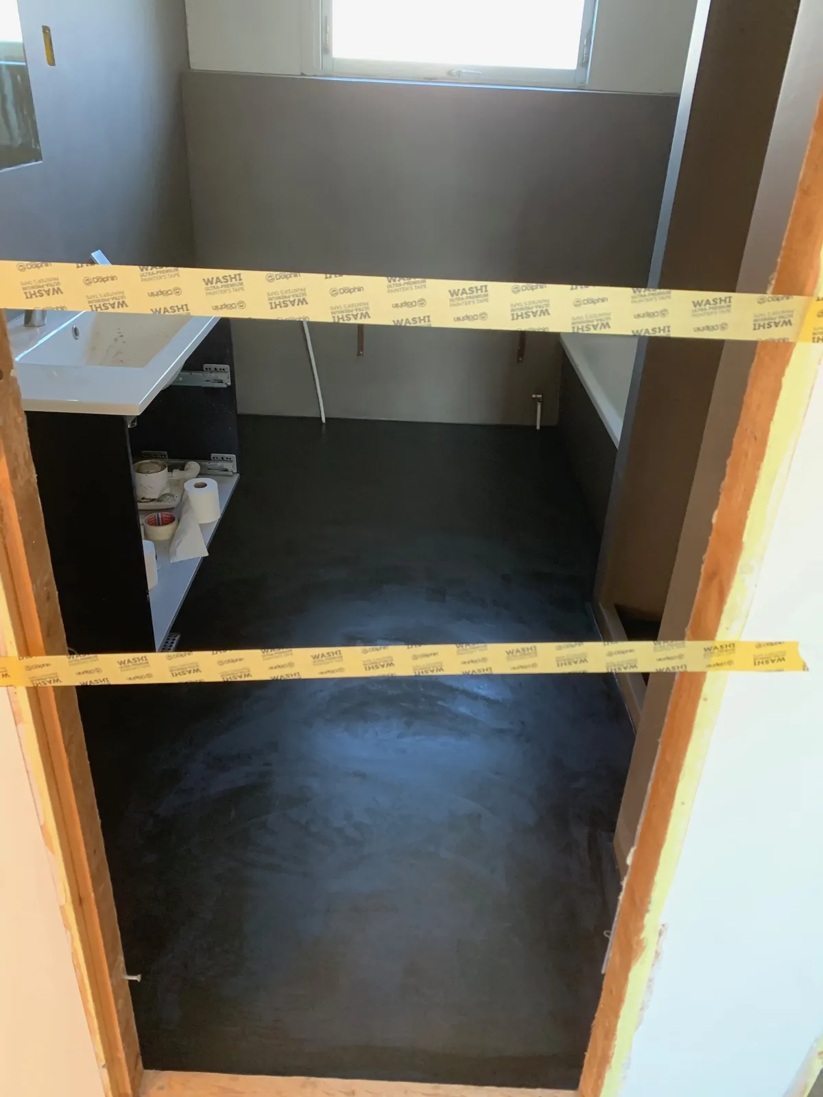 Sort gulv i badeværelse afdækket med tape – Maler Microcement, Herlev og omegn