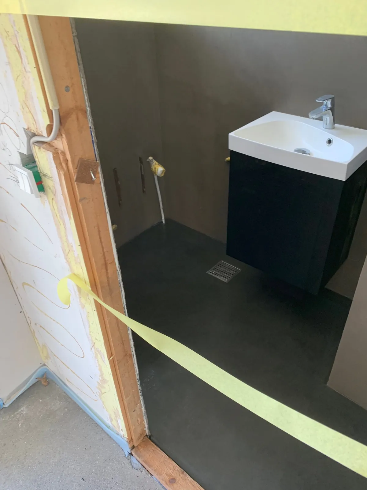 Sort gulv og håndvask på sort møbel – Maler Microcement, Herlev og omegn